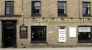 un bâtiment en briques avec l'hôtel géorge écrit sur lui dans l'établissement The George Hotel, à Chatteris