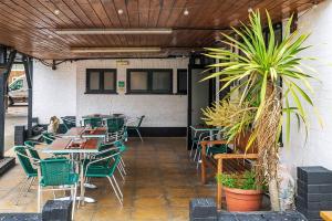 an empty restaurant with tables and chairs and plants at The George Hotel in Chatteris