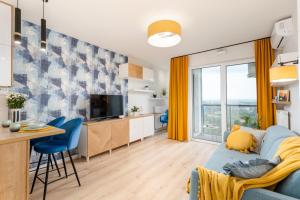 a living room and kitchen with a blue couch and a table at BlueApart Mogilska in Kraków