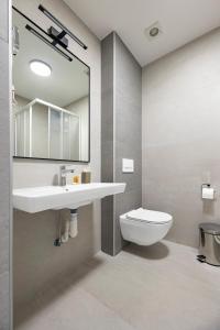 a bathroom with a sink and a toilet and a mirror at Regency Hotel in Chişinău