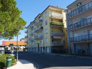 格拉多FIORE DI MARE - Delizioso bilocale con posto auto vicino al porto的黄色建筑前的一条空街道