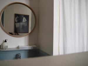 ein Bad mit einem Spiegel und einem Duschvorhang in der Unterkunft La suite Armel proposé par escaleasaintbriac in Saint-Briac-sur-Mer