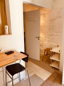 een kamer met een tafel, een stoel en een deur bij Casa Camões II in Porto