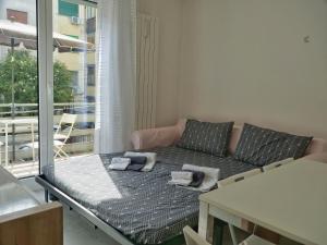 salon z kanapą i balkonem w obiekcie FIORE DI MARE - Delizioso bilocale con posto auto vicino al porto w Grado