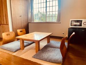 ein Esszimmer mit einem Holztisch und Stühlen in der Unterkunft SAMURISE NORTH in Fujikawaguchiko