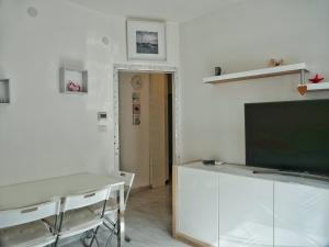 格拉多FIORE DI MARE - Delizioso bilocale con posto auto vicino al porto的客厅配有电视、书桌和桌子。