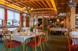 un comedor con mesas y sillas blancas en Hotel Sauerländer Hof, en Willingen