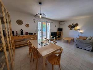 ein Wohnzimmer mit einem Tisch, Stühlen und einem Sofa in der Unterkunft Le Salvador - maisonnette pour 4 in Sigean