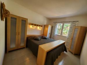 Schlafzimmer mit einem Bett, einem Tisch und einem Fenster in der Unterkunft Le Salvador - maisonnette pour 4 in Sigean