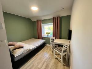 niewielka sypialnia z łóżkiem i biurkiem w obiekcie Sarnia Polana w mieście Kostrzyca