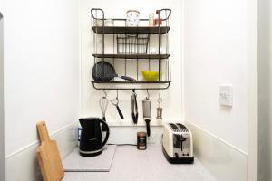 a kitchen with utensils on a shelf on the wall at Charming Apartment in the Heart of Camden in London