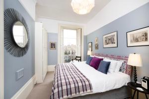 sypialnia z dużym łóżkiem i lustrem w obiekcie Charming Apartment in the Heart of Camden w Londynie
