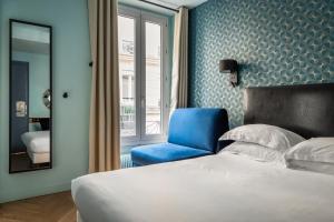 - une chambre avec un lit et une chaise bleue dans l'établissement Hotel Elysée Etoile, à Paris