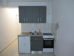 a small kitchen with black cabinets and a sink at Relax Beach Apartment in Split