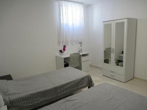 a bedroom with two beds and a desk and a mirror at Relax Beach Apartment in Split
