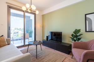 sala de estar con TV, sofá y mesa en Latte's Prime 1-Bedroom Apartment in Larnaca en Lárnaca