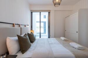 1 dormitorio con 1 cama blanca grande con almohadas en Latte's Prime 1-Bedroom Apartment in Larnaca en Lárnaca