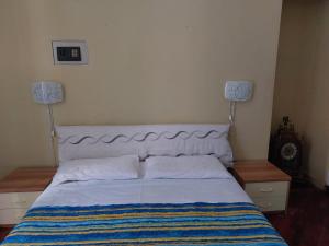 a bed in a bedroom with two nightstands and two lamps at Larysa in Sanremo