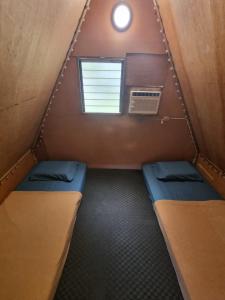 a small room with two beds and a window at Hagdan Reef Dive Spot by HiveRooms in Oslob