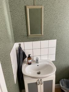 y baño con lavabo blanco y espejo. en Elisabets Vandrarhem Hemse, en Hemse