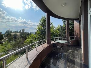 a balcony with a table and chairs on a building at Mona Hotel and Cottages in Lankaran