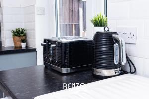 a toaster oven sitting on a counter in a kitchen at Cosy 3-bed Home in Nottingham by Renzo, Driveway for 2 Cars, Perfect for Contractors! in Nottingham