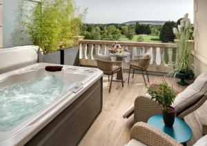 a hot tub on a balcony with a table and chairs at La Côte Saint Jacques in Joigny