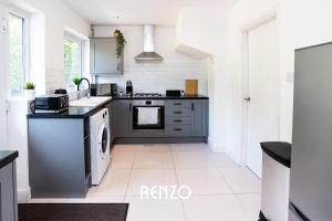 a kitchen with black and white appliances at Cosy 3-bed Home in Nottingham by Renzo, Driveway for 2 Cars, Perfect for Contractors! in Nottingham