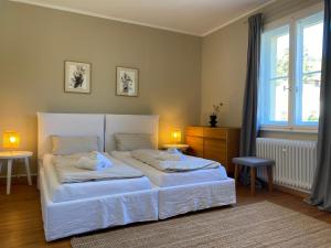 ein Schlafzimmer mit einem Bett, zwei Tischen und einem Fenster in der Unterkunft Exklusives Ferienhaus in Top Lage: Der Johannishof in Würzburg