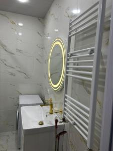 a white bathroom with a sink and a mirror at Apartment in Agmashenebeli in Tbilisi City