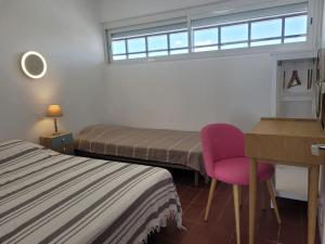 - une chambre avec deux lits, un bureau et une chaise dans l'établissement Le Front de mer - vue imprenable, à Port-la-Nouvelle