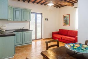 a kitchen and a living room with a red couch at Farfalla in Montiano