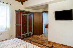 een slaapkamer met een bed en een tv aan de muur bij Farfalla in Montiano