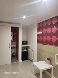 salon ze stołem i czerwoną ścianą w obiekcie Hostal Inn Madrid w Madrycie