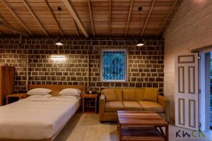 a bedroom with two beds and a couch at Tranquilla in Nikapota +18 photos