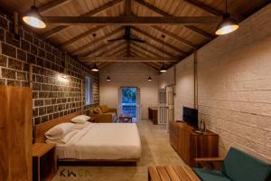 a bedroom with a bed and a couch and a tv at Tranquilla in Nikapota