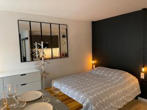 um quarto com uma cama e uma mesa com copos de vinho em Grand Studio - Strasbourg em Estrasburgo