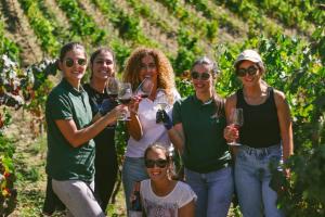 eine Gruppe von Menschen, die auf einem Weingut stehen und Weingläser halten in der Unterkunft Casa d'Arcã in Alijó