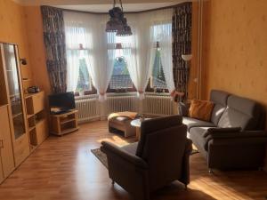 sala de estar con sofá, sillas y ventanas en Haus Gertrud, en Bad Sachsa
