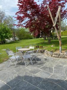 una mesa y sillas sentadas en un patio de piedra en La maison du petit bonheur, en Moutier