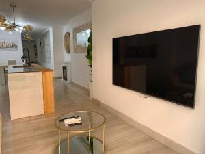 a living room with a large flat screen tv on a wall at Apartamento Center Playa Almerimar in Almerimar