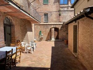 d'une terrasse avec des tables et des chaises dans un bâtiment en briques. dans l'établissement Fonte 6: Centro vicino piazza del Campo, à Sienne