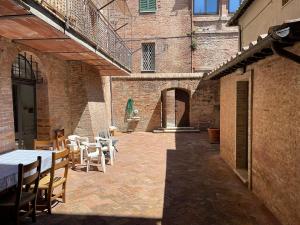 a patio with tables and chairs in a brick building at Fonte 6: Centro vicino piazza del Campo in Siena