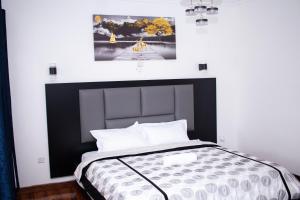 a bed with a black and white headboard in a room at The Country Side Villa - Nanyuki in Nanyuki