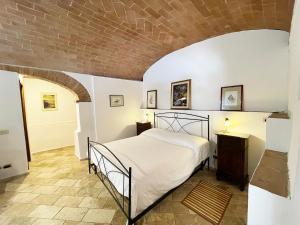a bedroom with a bed and a brick wall at Fonte 6: Centro vicino piazza del Campo in Siena
