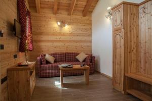 - un salon avec un canapé et une table dans l'établissement Chalet Camping Faè 4 - Trilocale, à Madonna di Campiglio