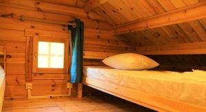 1 dormitorio con 1 cama en una cabaña de madera en Chalet Pyrénéen, en Saint-Ybars