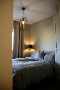 a bedroom with a bed and a chandelier at Stylish 3-room apartment with balcony and free parking in Oslo