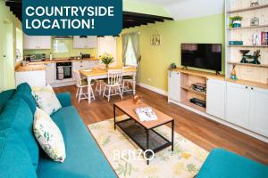 uma sala de estar com um sofá azul e uma mesa em Cosy 1-bed Cottage in Stoke Bardolph, Nottingham by Renzo, Stunning Countryside Location! em Burton Joyce