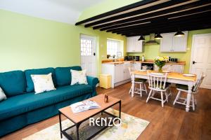 Burton Joyce的住宿－Cosy 1-bed Cottage in Stoke Bardolph, Nottingham by Renzo, Stunning Countryside Location!，客厅配有蓝色的沙发和桌子